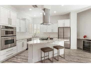 Modern kitchen boasts stainless steel appliances, a gas cooktop, and a granite countertop island with seating at 9228 Whitekirk Pl, Las Vegas, NV 89145
