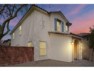 Charming two-story home with stucco exterior, tile roof, and beautiful blue shutters under a dusk sky at 10943 Ketchikan St, Las Vegas, NV 89179