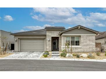 Charming single-story home featuring a gray stone facade, two car garage, and well-maintained landscaping at 11137 Black Fire Opal Dr, Las Vegas, NV 89138