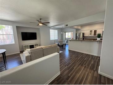 Spacious living room with modern furnishings and dark wood vinyl flooring at 1725 Queen Victoria St # 103, Las Vegas, NV 89144