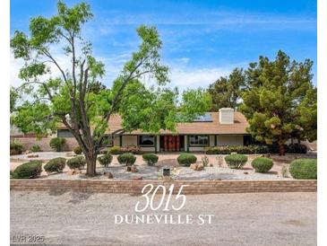 Charming single story home featuring a lush front yard with mature trees and shrubs at 3015 Duneville St, Las Vegas, NV 89146