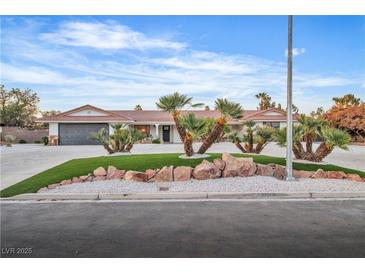Charming single-story home featuring a well-manicured lawn, mature landscaping, and a three-car garage at 3334 W Mardon Ave, Las Vegas, NV 89139