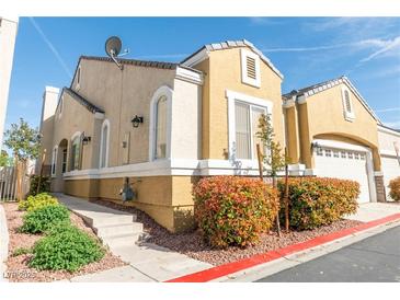 A charming two-story home with a tan exterior and landscaped front yard on a sunny day at 928 Collingtree St, Las Vegas, NV 89145