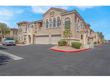 Beautiful stucco two-story home showcasing a two-car garage, manicured landscaping, and ample parking at 10550 W Alexander Rd # 2064, Las Vegas, NV 89129