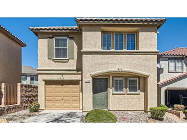 Charming two-story home with a tan stucco exterior, complemented by a one-car garage and well-maintained landscaping at 1129 Paradise Vista Dr, Henderson, NV 89002