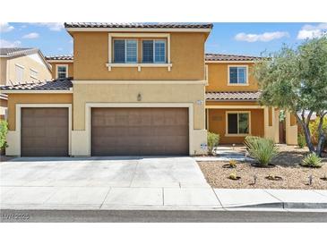 Two-story home with a three-car garage, desert landscaping, and a tan and brown color palette at 1776 Gentle Brook St, North Las Vegas, NV 89084