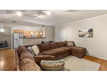 Open-concept living room featuring a comfortable sectional sofa and hardwood floors at 5855 Valley Dr # 1080, North Las Vegas, NV 89031