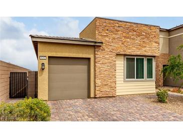 Charming home featuring a stone facade, neutral stucco, two-car garage, and paved driveway at 8242 Vino Merlot Ave, Las Vegas, NV 89113