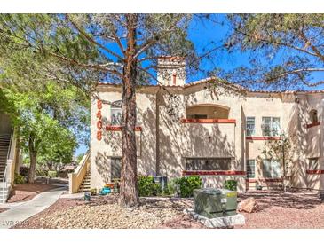 Charming two-story stucco building with red tile roof and desert landscaping at 8408 Running Deer Ave # 201, Las Vegas, NV 89145