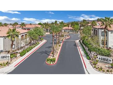 Community street with palm trees and a view of well-maintained townhomes in a desert environment at 950 Seven Hills Dr # 124, Henderson, NV 89052