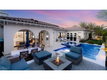 Inviting backyard oasis with a sparkling pool, fire pit, and comfortable seating under a beautiful sunset sky at 10717 Beringer Dr, Las Vegas, NV 89144