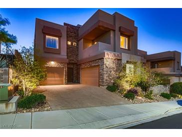 Modern two-story home showcasing stone accents, a two-car garage, and desert landscaping at 261 Crimson Edge St, Henderson, NV 89012