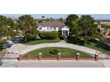 Elegant two-story home with mature trees, circular driveway, and manicured front lawn at 5860 N Campbell Rd, Las Vegas, NV 89149