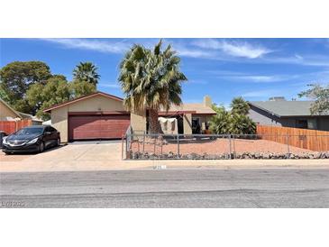 Charming single-story home features a two-car garage and desert landscaping with a secure chain link fence at 625 Fernbrook Dr, Henderson, NV 89002