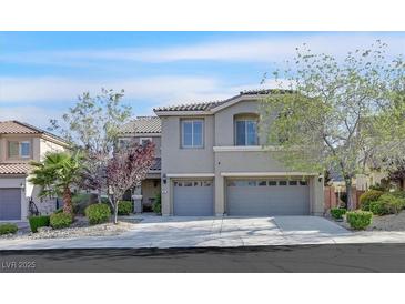 Charming two-story home featuring an attached two-car garage, and desert landscaping at 65 Pangloss St, Henderson, NV 89002