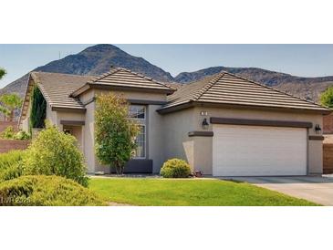 Charming single-story home with a well-manicured lawn and mountain views at 701 Smokey Mountain Ave, Henderson, NV 89012
