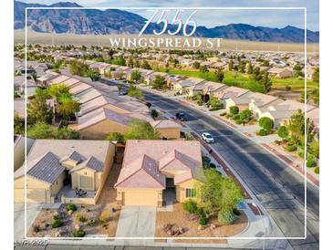 Expansive aerial view of the home in a lovely community with desert landscaping and mountain views at 7556 Wingspread St, North Las Vegas, NV 89084