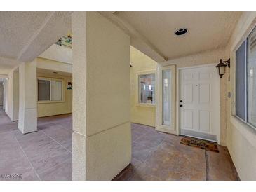 Welcoming entryway with a white door, textured walls, and covered patio space at 210 E Flamingo Rd # 105, Las Vegas, NV 89169