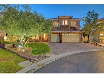 Beautiful two-story home boasts a well-manicured lawn, mature landscaping, and a paver driveway leading to a two-car garage at 4651 Munich Ct, Las Vegas, NV 89147