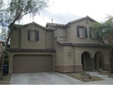 Two story home showcasing the garage and an arched entryway at 7173 Las Colinas Ave, Las Vegas, NV 89179