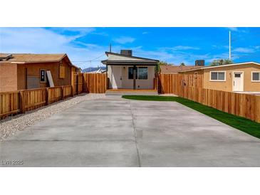 Expansive backyard featuring a concrete driveway and a patch of green artificial grass at 974 Balzar Ave, Las Vegas, NV 89106