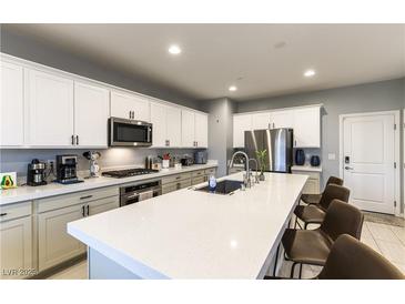 Modern kitchen features a large island with quartz countertops and stainless steel appliances at 10372 Thurso Ave, Las Vegas, NV 89166