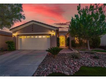 Inviting single-story home showcasing a tidy front yard and a convenient two-car garage at sunset at 10581 Santo Marco Ct, Las Vegas, NV 89135