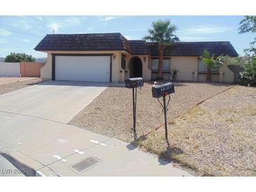Single-story home featuring desert landscaping, a two-car garage, and a unique roof at 230 Queen Marie Ct, Henderson, NV 89015