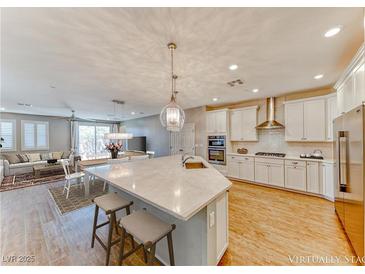 Modern kitchen featuring a large island with seating, stainless steel appliances, and an open floor plan at 2767 Flowing Breeze St, Henderson, NV 89044