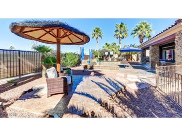 Beautiful backyard pool area with an umbrella-covered seating area, perfect for outdoor relaxation and entertaining at 8209 Chapelle Ct, Las Vegas, NV 89131