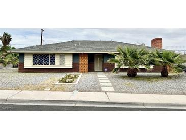 Charming single-story home featuring a unique window design and mature palm trees at 1801 Griffith Ave, Las Vegas, NV 89104