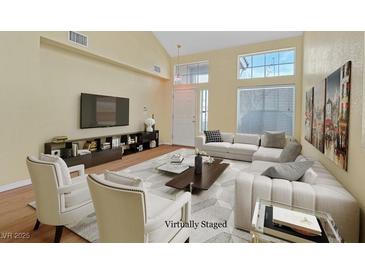 Bright living room featuring vaulted ceilings, updated furniture, and an abundance of natural light at 681 Peach Coral St, Las Vegas, NV 89183
