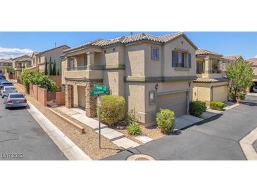 Two-story home with a covered front porch, desert landscaping, and an attached two-car garage at 7865 Solid Horn Ct, Las Vegas, NV 89149