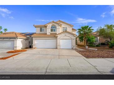 Inviting two-story home with attached two-car garage and a charming desert landscape at 9021 Canyon Magic Ave, Las Vegas, NV 89129