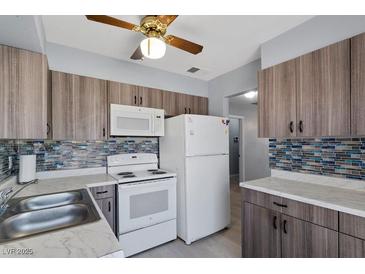 An updated kitchen with stainless steel appliances, stylish cabinets, and modern backsplash at 1643 E St, Las Vegas, NV 89106