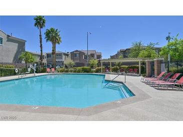 Sparkling community pool with lounge chairs and meticulously maintained landscaping in a gated community at 8919 Don Valley Ave, Las Vegas, NV 89148