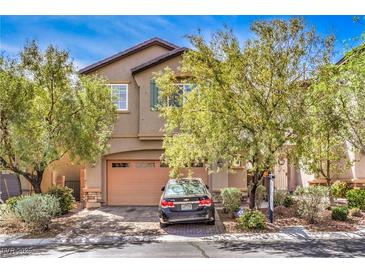 Charming stucco home with a two-car garage and front yard landscaping at 10509 Hartford Hills Ave, Las Vegas, NV 89166