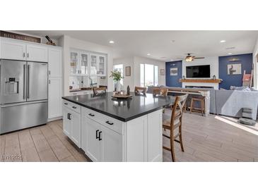 Bright, modern kitchen features stainless steel appliances, a large island with dark countertop, and an open floor plan at 10729 Marathon Bell Ln, Las Vegas, NV 89129