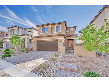 Beautiful two-story home with a modern design, attractive brick driveway, and low-maintenance desert landscaping at 244 Native Stone St, Las Vegas, NV 89138