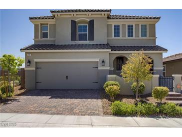 Charming two-story home featuring a brick driveway, two-car garage, and manicured landscaping at 2581 Tolmezzo St, Henderson, NV 89044