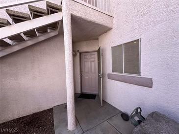 Entryway featuring stucco walls, an open door, and a concrete staircase leading up to the next level at 4555 E Sahara Ave # 166, Las Vegas, NV 89104