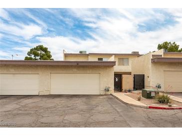 Inviting townhouse with attached garages under a partly cloudy blue sky at 555 Rene Ln, Henderson, NV 89015