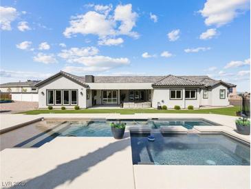 A luxurious pool and backyard with modern design and inviting patio space with a view of the rear exterior of the home at 5865 Egan Crest Dr, Las Vegas, NV 89149