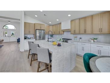 A spacious kitchen featuring a marble island, stainless steel appliances, and light wood cabinets at 1594 Pontine Ct, Henderson, NV 89052