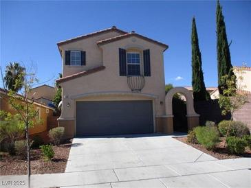 Inviting two-story home featuring a gray two-car garage and a terracotta-tiled roof at 2381 Lilac Cove St, Las Vegas, NV 89135