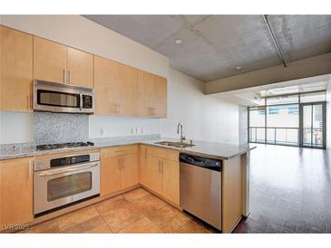 Modern kitchen features stainless steel appliances, granite countertops, and light wood cabinetry at 353 E Bonneville Ave # 503, Las Vegas, NV 89101