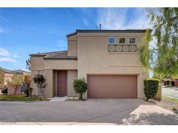 Charming two-story home with a two-car garage and desert landscaping under a clear blue sky at 644 Chase Tree St, Las Vegas, NV 89144