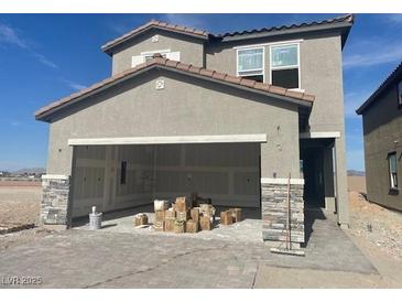 Modern two-story home with gray stucco and a spacious two-car garage featuring stone accents at 9548 Hinson St, Las Vegas, NV 89139