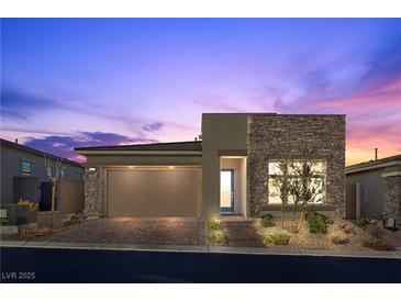 Beautiful one-story home featuring a two-car garage, stone accents, and desert landscaping at 12476 Heritage Bend Dr, Las Vegas, NV 89138