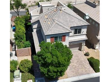 Charming two-story home with a brick driveway, lush landscaping, and well-maintained roof tiles at 7788 Ebro Valley Ct, Las Vegas, NV 89113